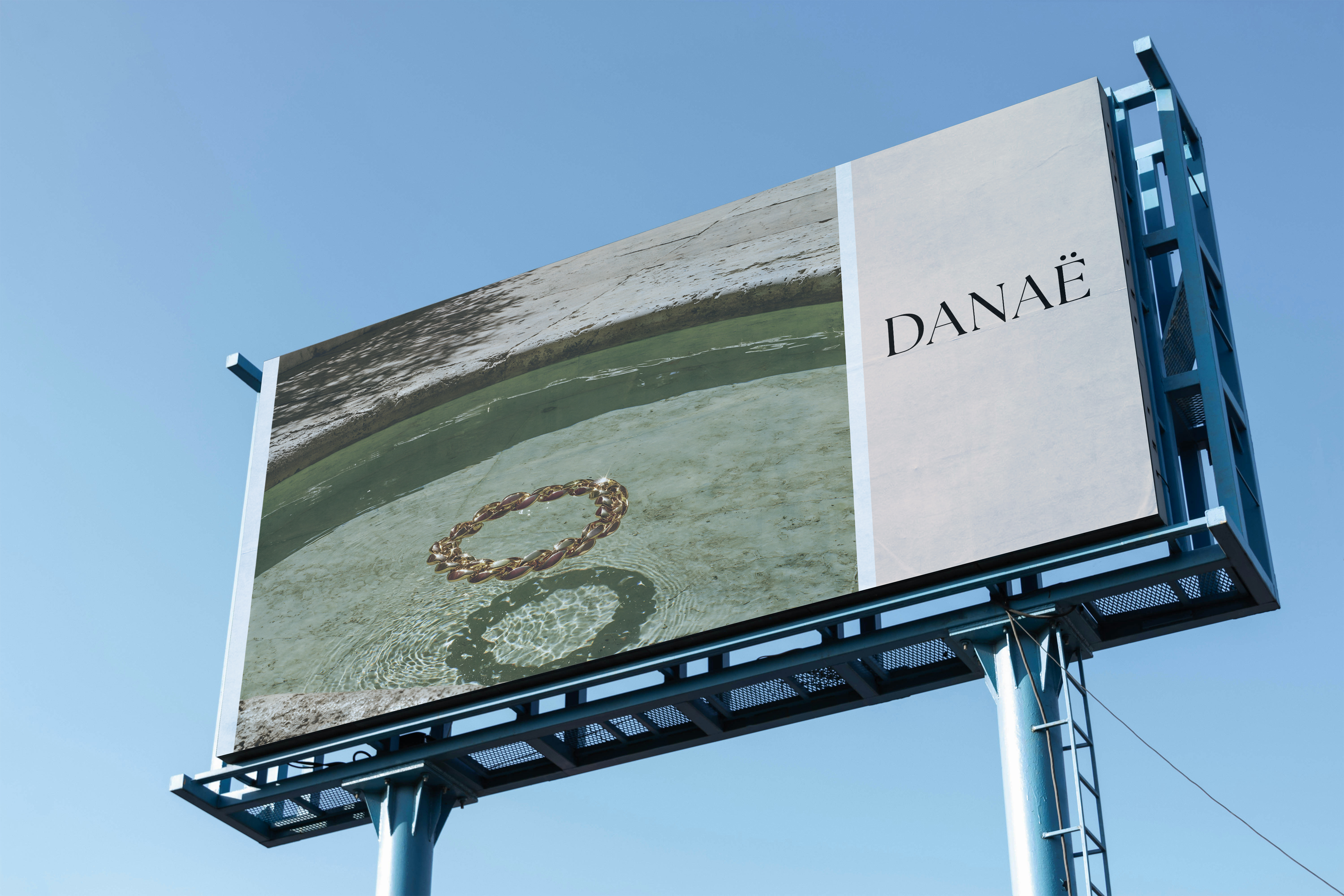 DANAË campaign billboard — chain bracelet in water